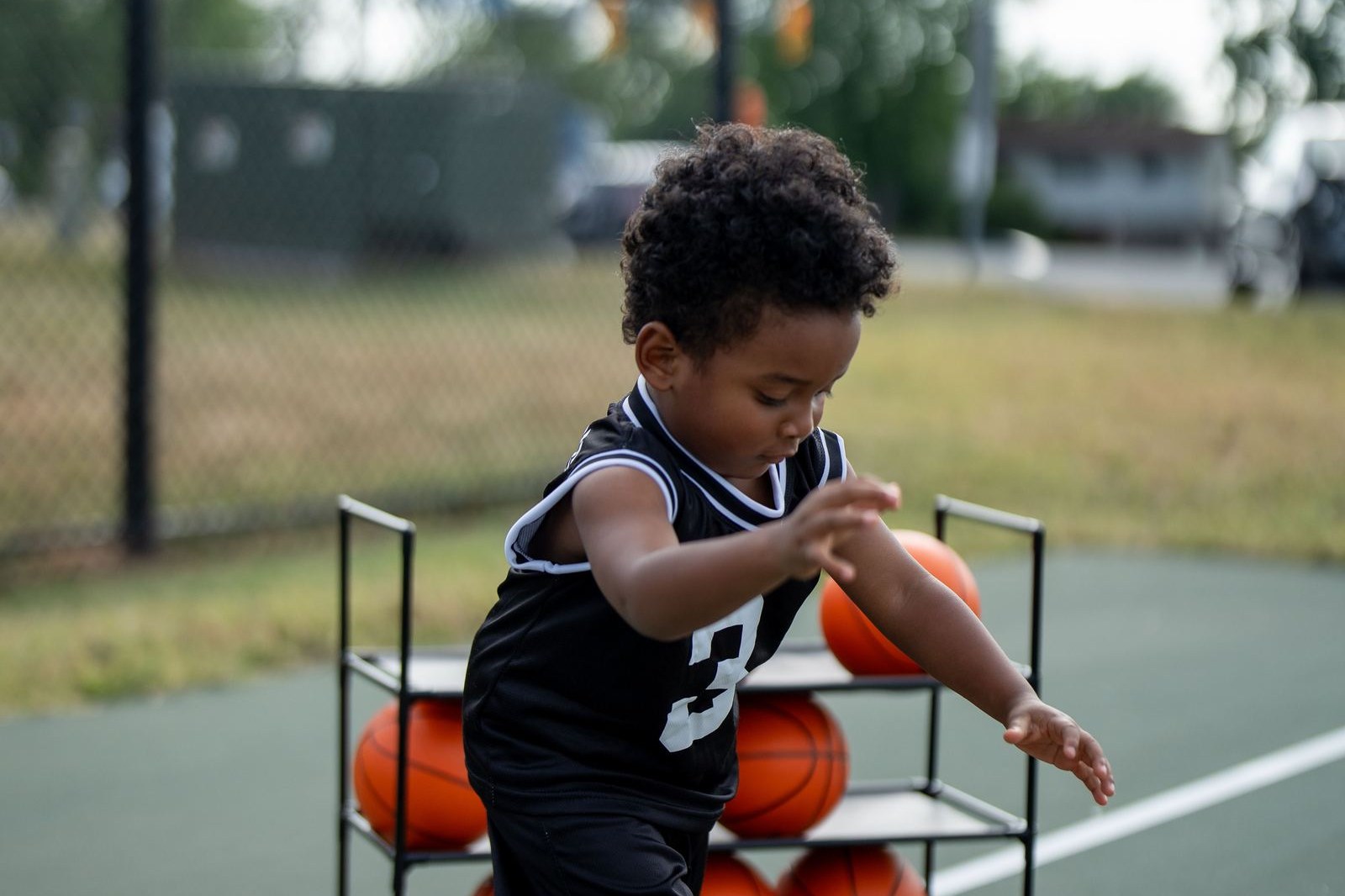 Young basketball player holding a ball on an outdoor court